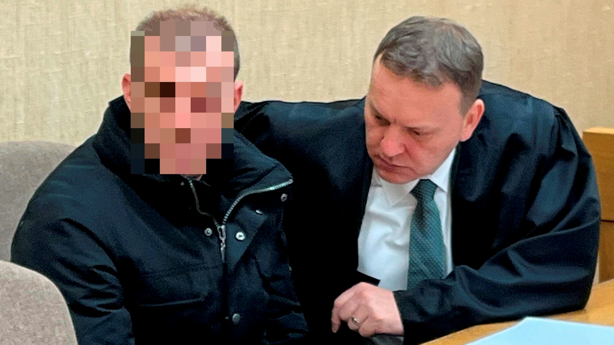 Der Angeklagte sitzt neben seinem Anwalt.