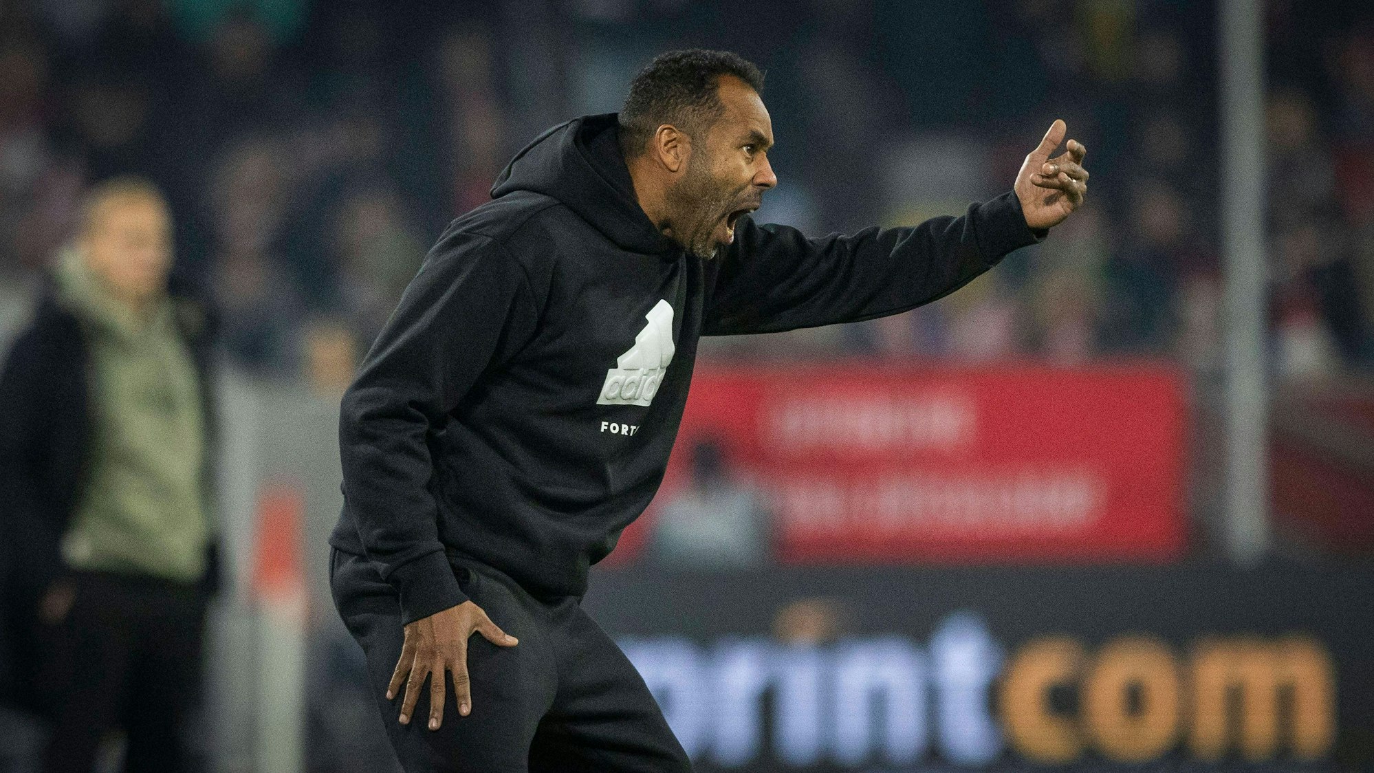 Fortuna Düsseldorfs Cheftrainer Daniel Thioune dirigiert sein Team im Spiel gegen den FC Schalke 04 an der Seitenlinie.