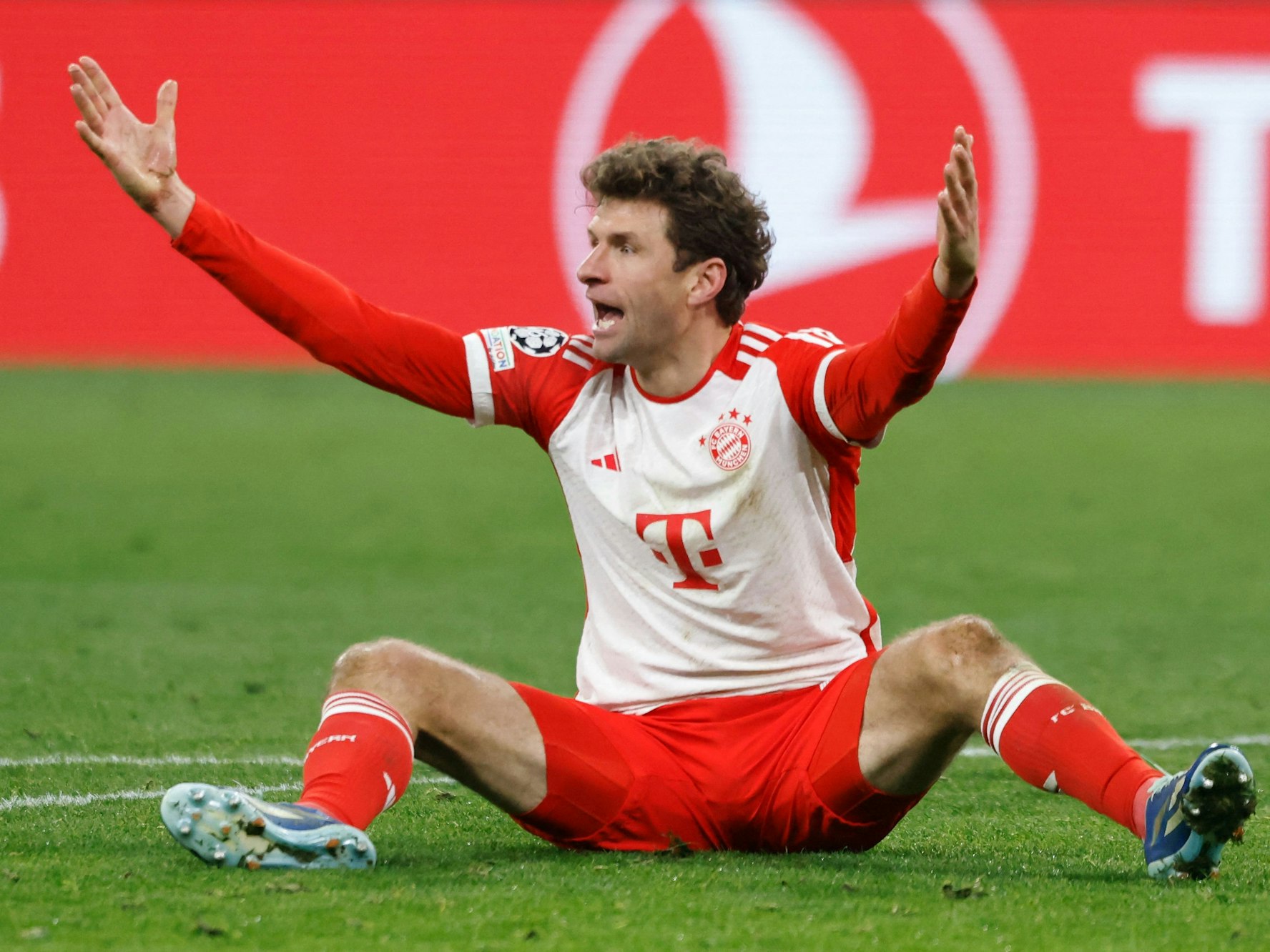 Thomas Müller sitzt auf dem Boden und gestikuliert.