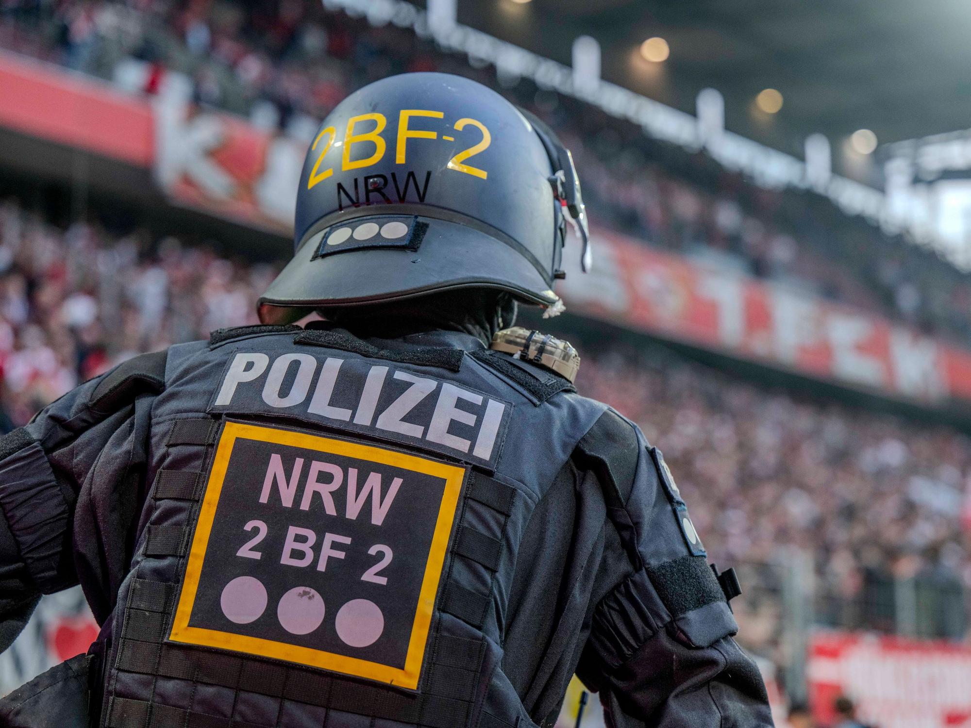 Ein Polizist im Rhein-Energie-Stadion beobachtet die Fans auf den Tribünen.