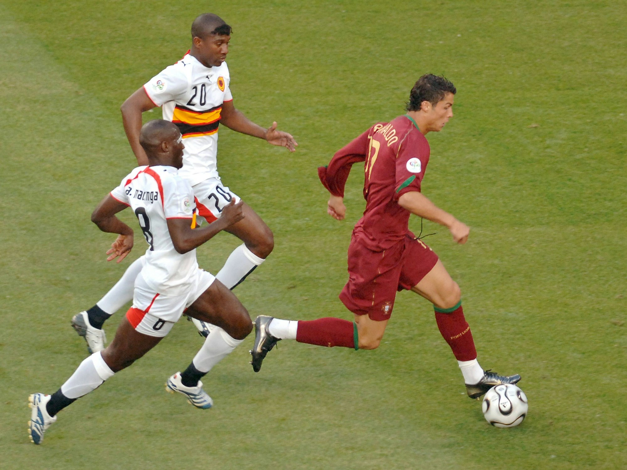 Cristiano Ronaldo im Zweikampf mit zwei angolanischen Spielern während der WM 2006 in Köln.