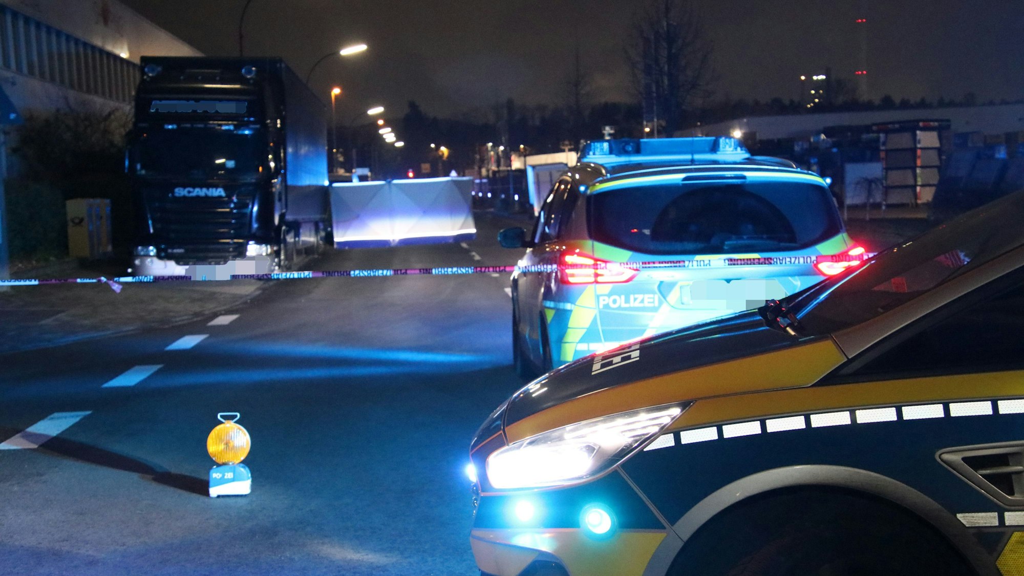 Die Polizei hat eine Straße abgesperrt, davor stehen zwei Streifenwagen.