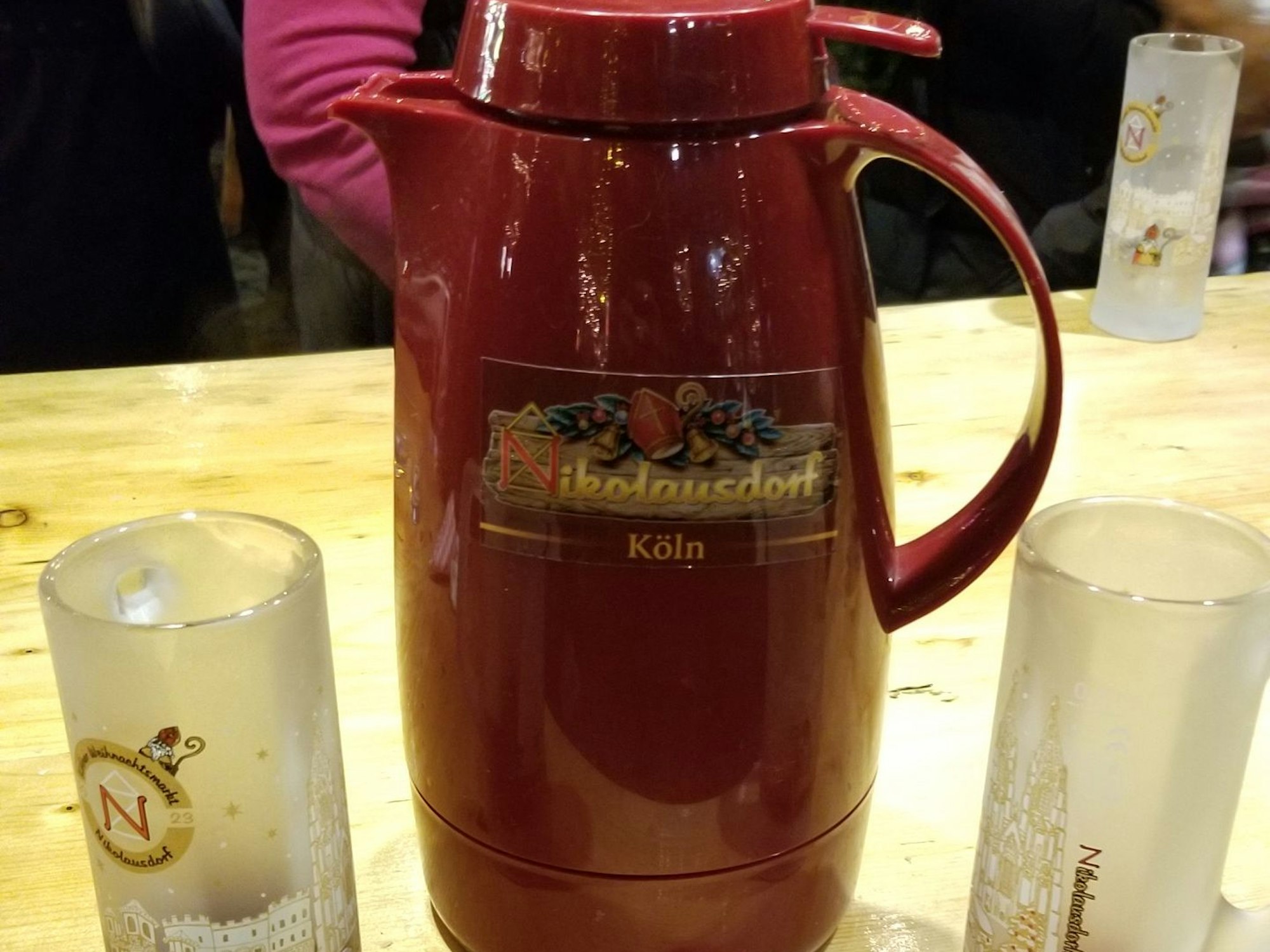 Eine Thermoskanne mit Glühwein steht auf einem Tisch auf dem Weihnachtsmarkt am Rudolfplatz in Köln.