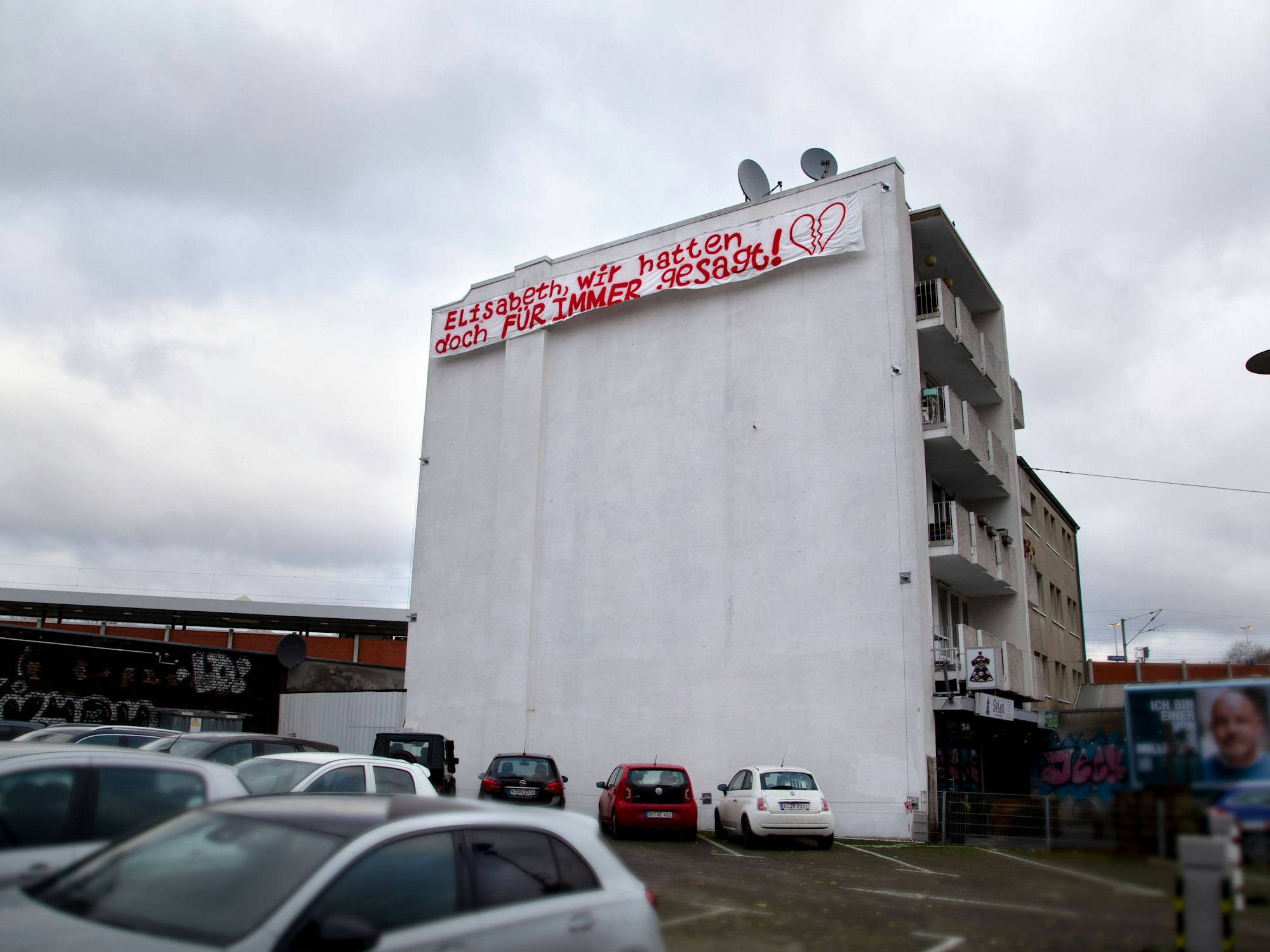 Ein Liebesplakat mit der Aufschrift „Elisabeth, wir hatten doch für immer gesagt“ hängt an einer Kölner Hauswand.