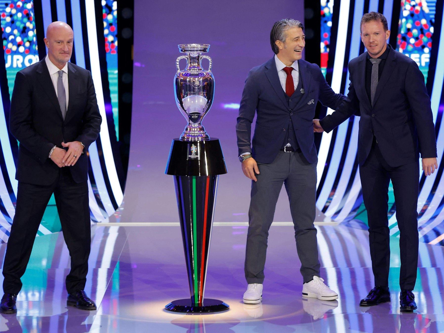 Marco Rossi, der Schweizer Coach Murat Yakin und Bundestrainer Julian Nagelsmann neben dem EM-Pokal.