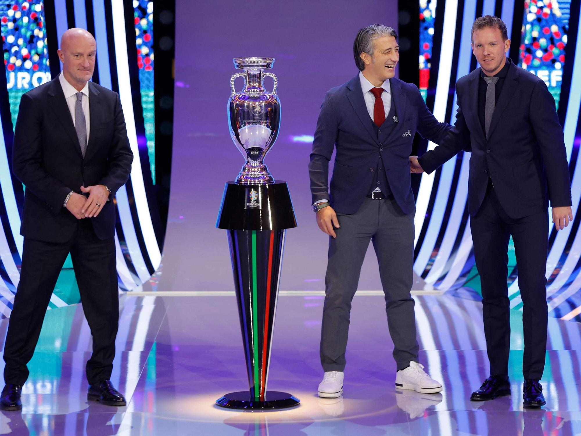 Marco Rossi, der Schweizer Coach Murat Yakin und Bundestrainer Julian Nagelsmann neben dem EM-Pokal.