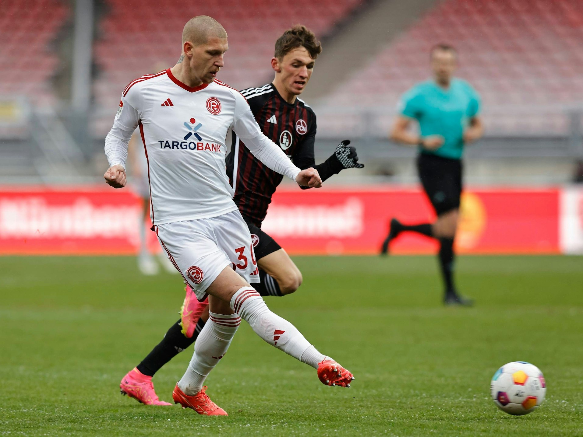 Fortuna Düsseldorfs Jordy de Wijs passt den Ball, Nürnbergs Benjamin Goller läuft hinterher.