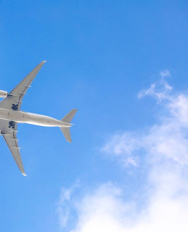 Blick von unten auf ein Flugzeug im Himmel.