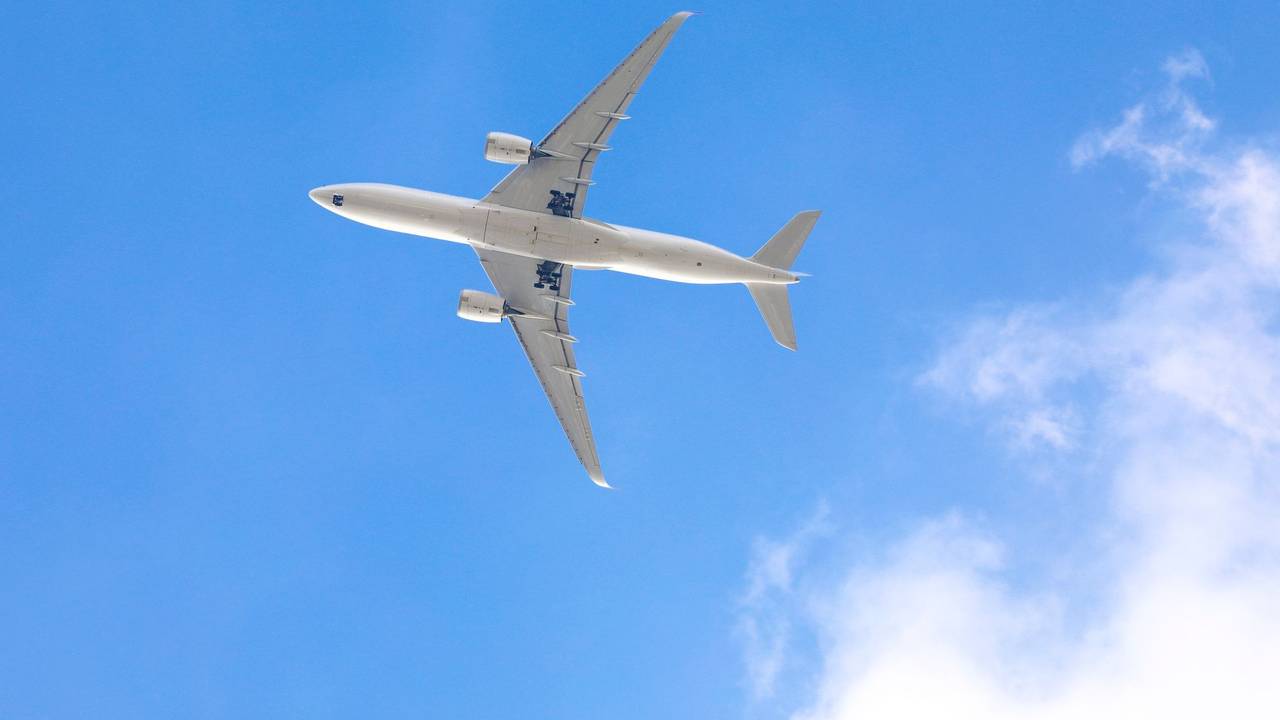 Blick von unten auf ein Flugzeug im Himmel.