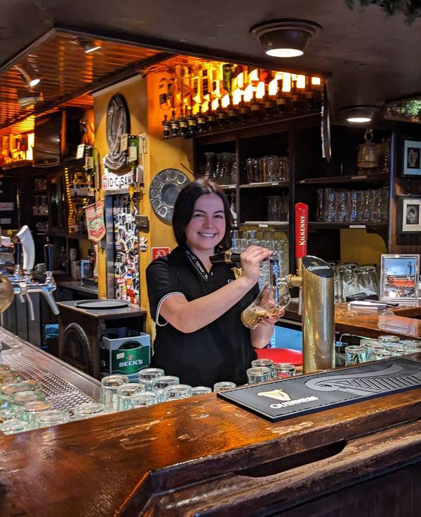 Paula zapft im Irish Pub Bier.