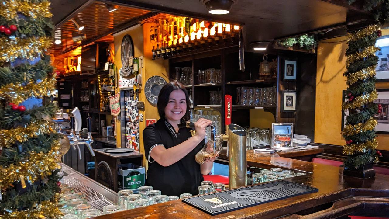 Paula zapft im Irish Pub Bier.