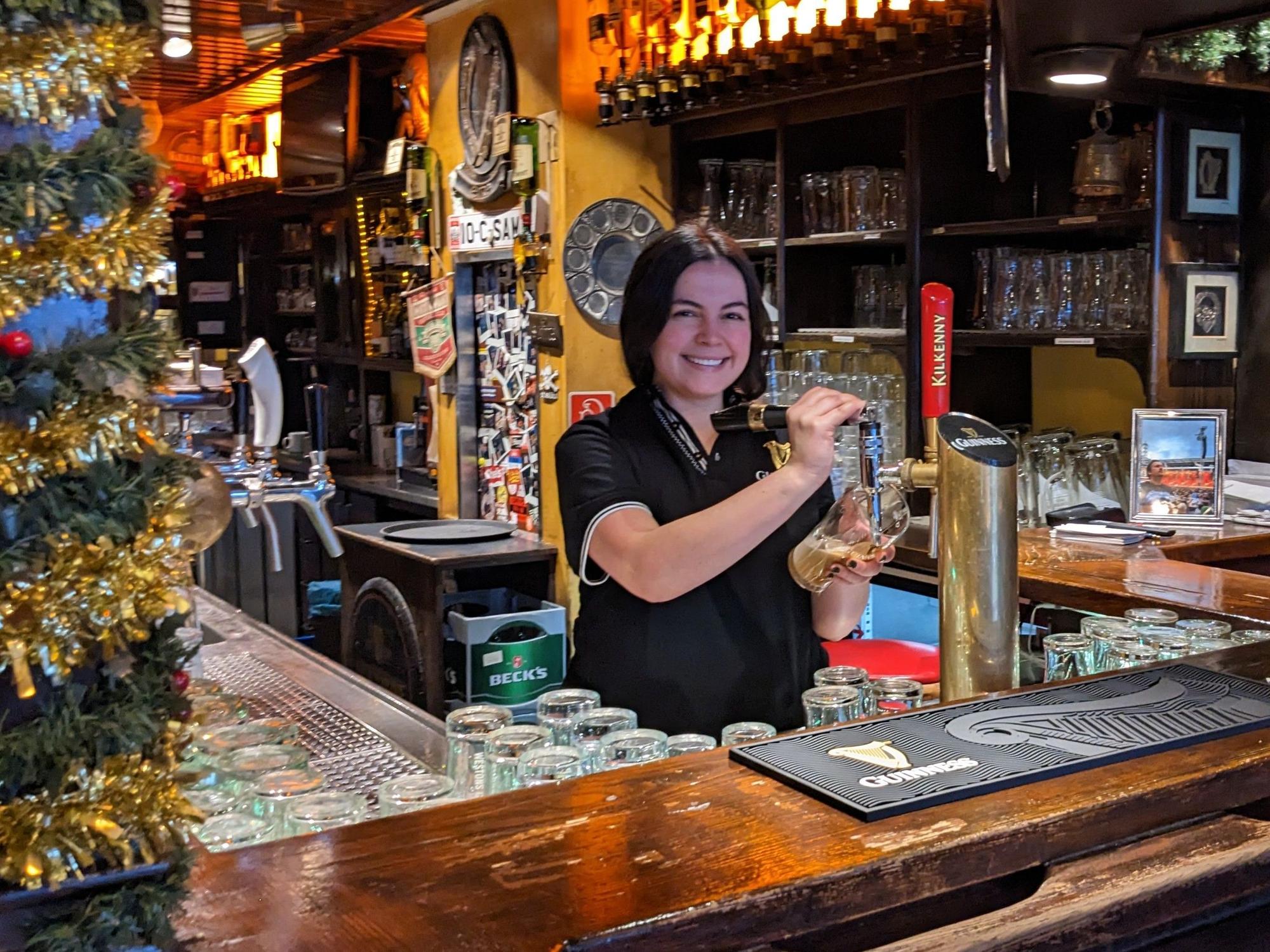 Paula zapft im Irish Pub Bier.