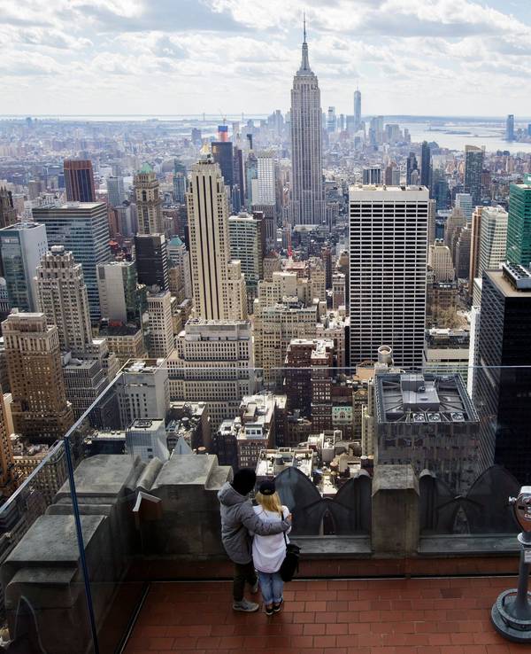 Zwei Personen blicken von der Aussichtsplattform auf dem Top of the Rock im Rockefeller Center in New York, New York, USA, auf die Skyline, 18. März 2016.