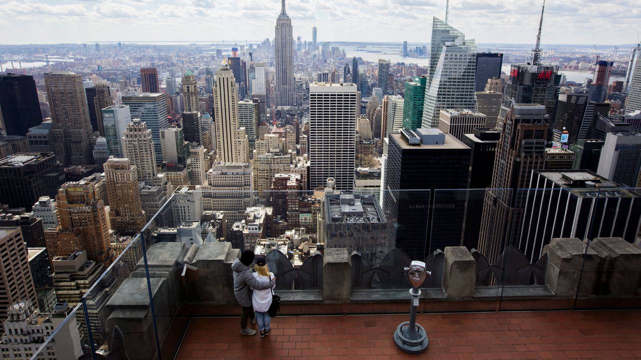 Zwei Personen blicken von der Aussichtsplattform auf dem Top of the Rock im Rockefeller Center in New York, New York, USA, auf die Skyline, 18. März 2016.