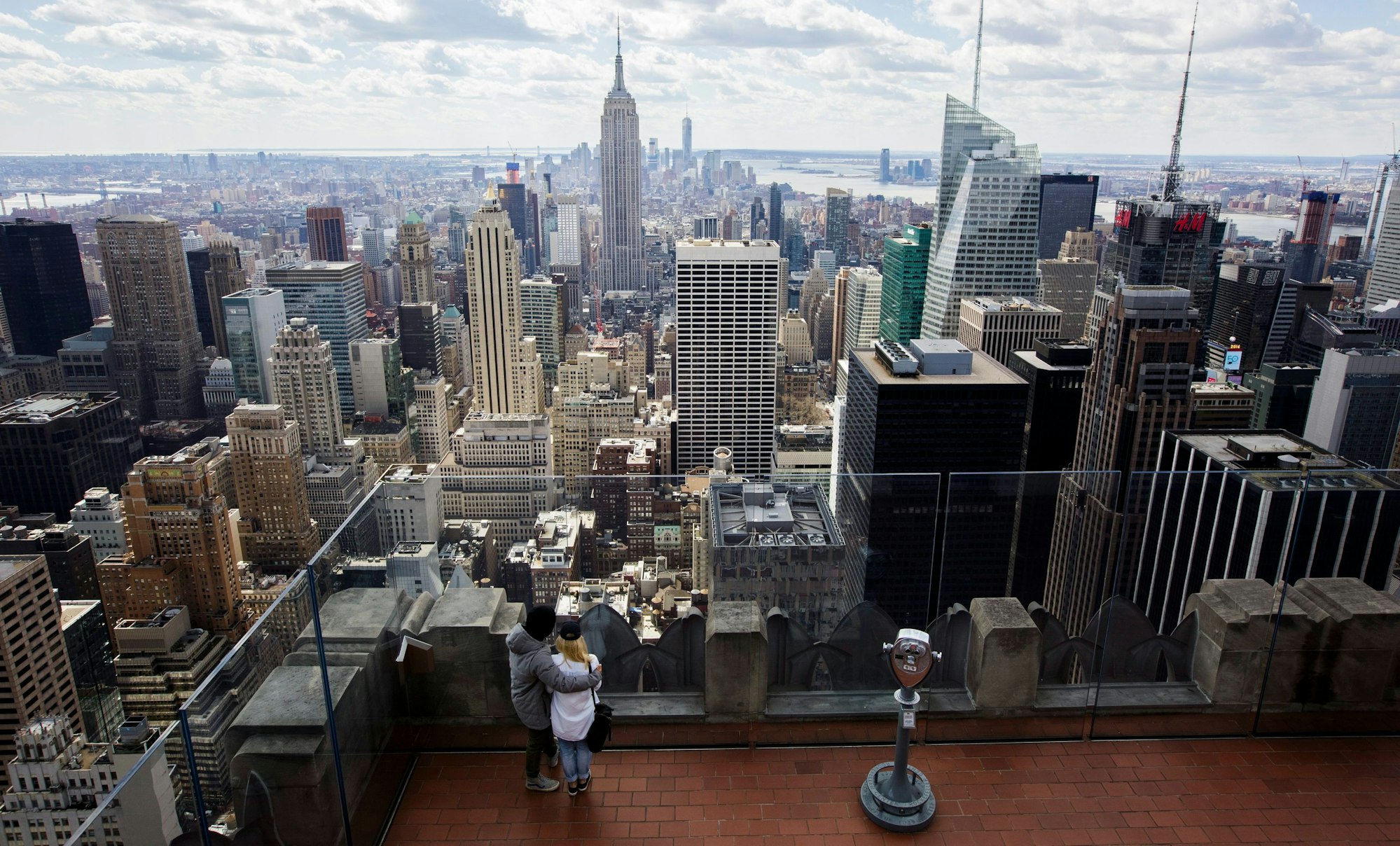Zwei Personen blicken von der Aussichtsplattform auf dem Top of the Rock im Rockefeller Center in New York, New York, USA, auf die Skyline, 18. März 2016.