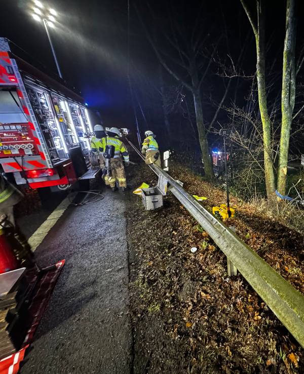 Feuerwehr in Bergisch Gladbach im Einsatz an einer Böschung, wo ein Auto in die Tiefe gestürzt ist.
