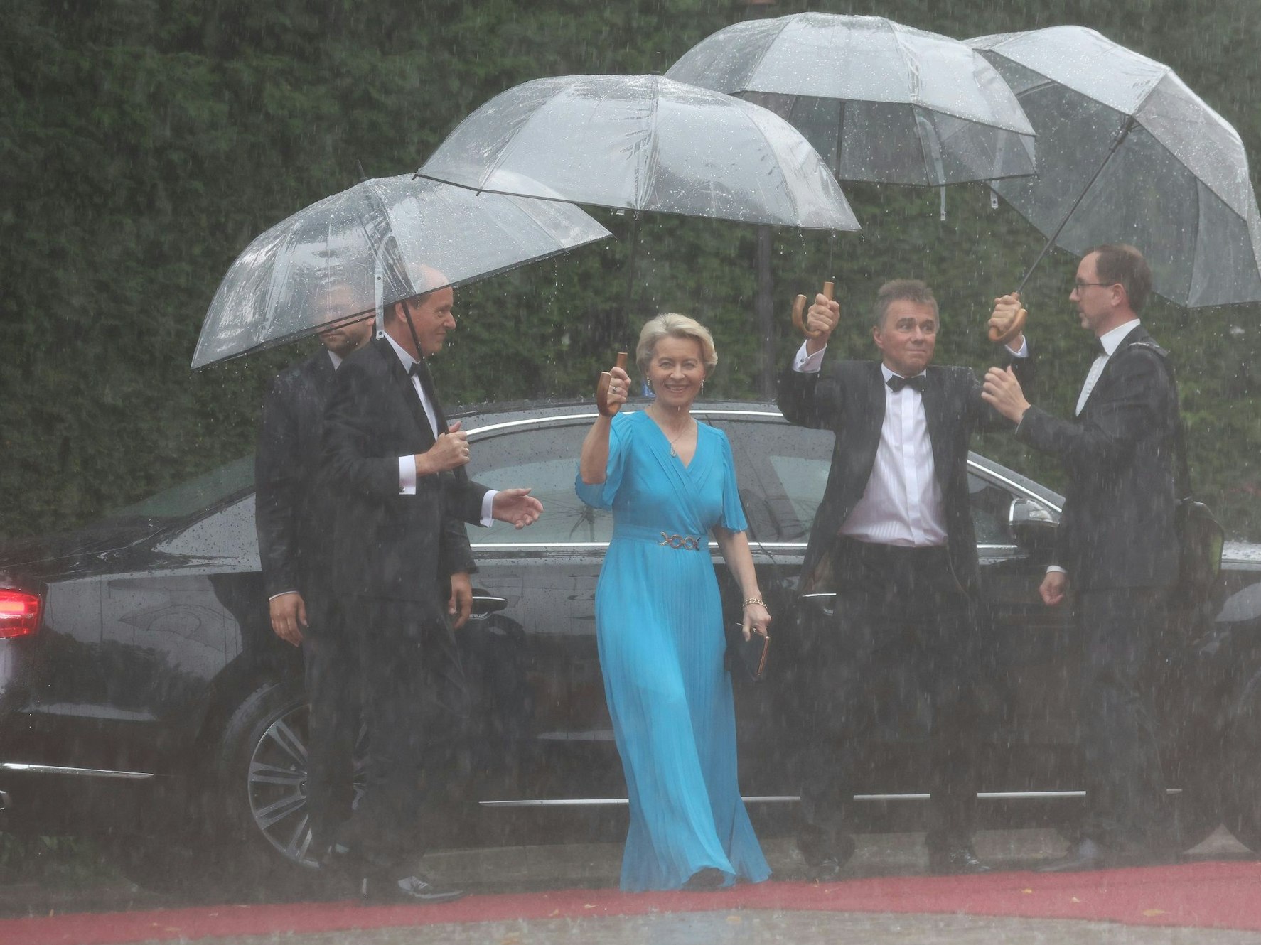 Ursula von der Leyen (CDU), Präsidentin der EU-Kommission, und Ehemann Heiko kommen bei Regen zur Eröffnung der Richard-Wagner-Festspiele im Juli 2023.