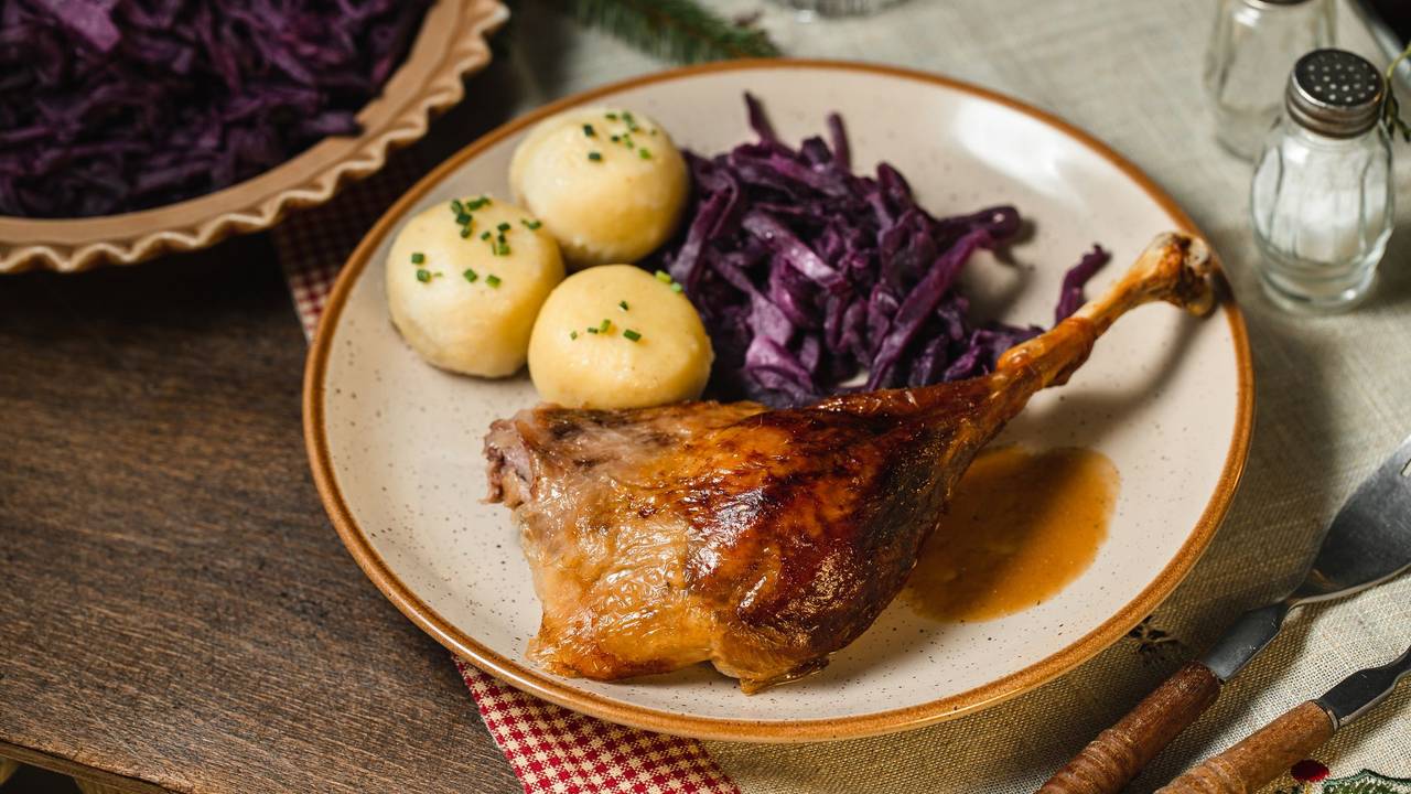 Ein Teller mit einem Weihnachtsbraten, Knödeln und Rotkohl.