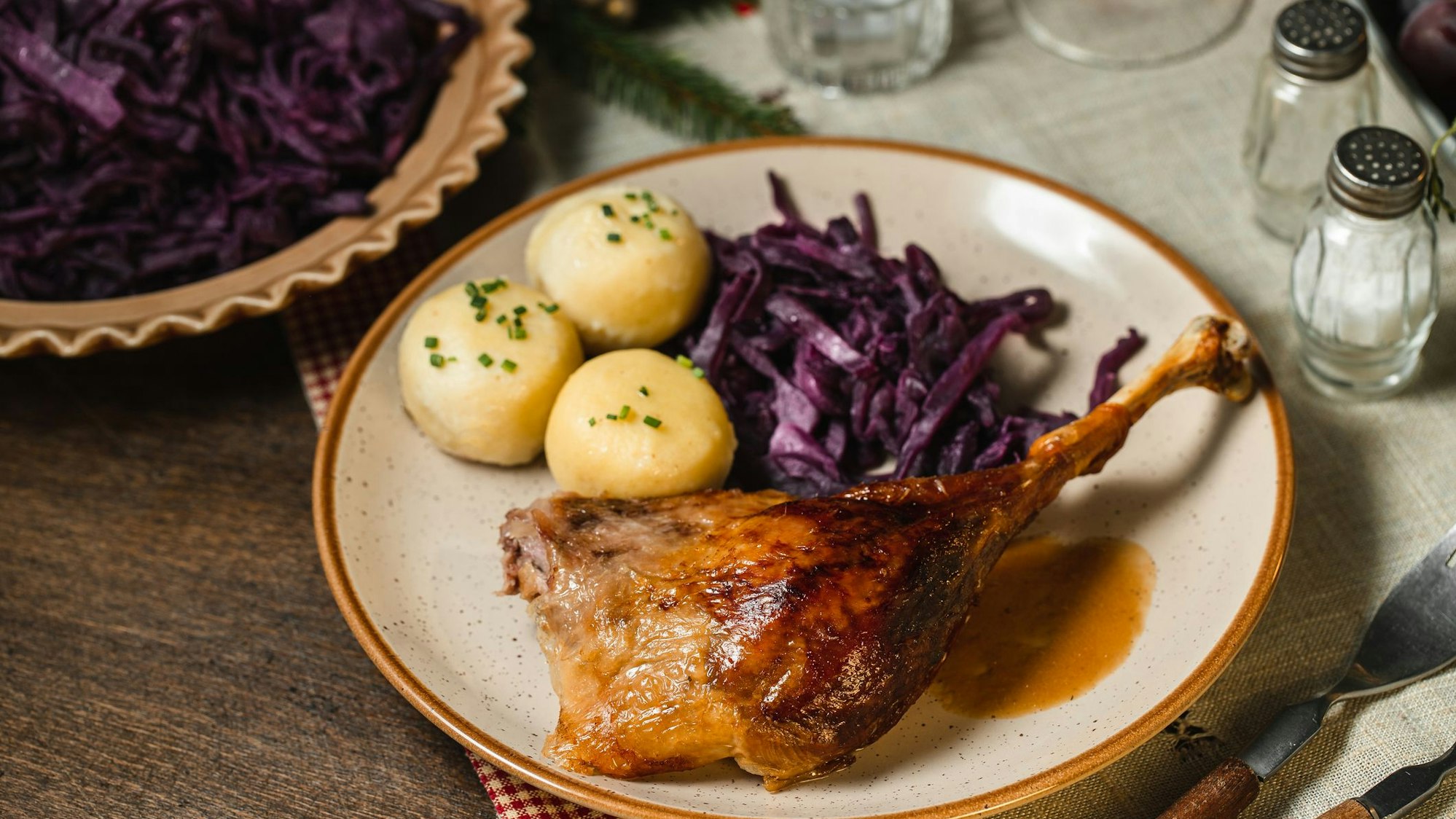 Ein Teller mit einem Weihnachtsbraten, Knödeln und Rotkohl.