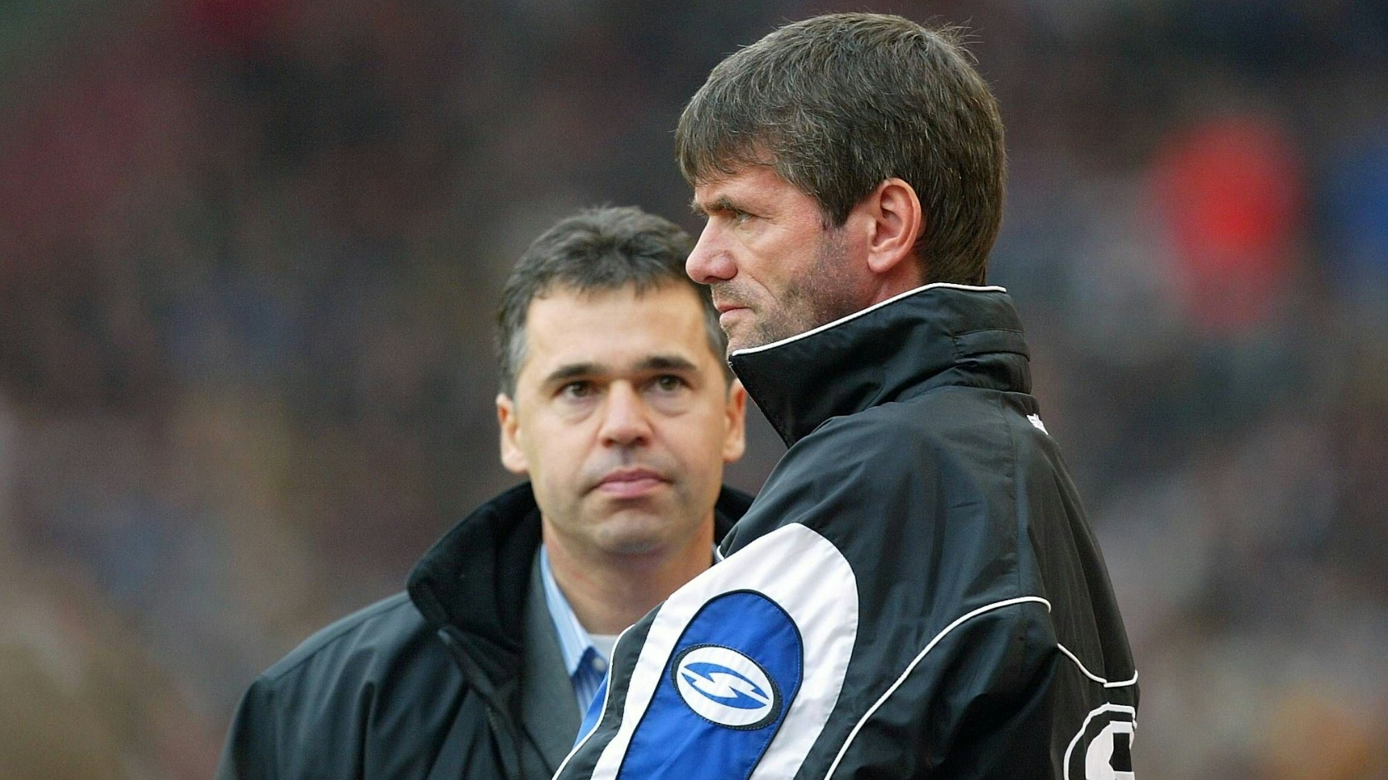 Friedhelm Funkel und Andreas Rettig stehen bei einem Spiel des 1. FC Köln im Oktober 2003 an der Seitenlinie.