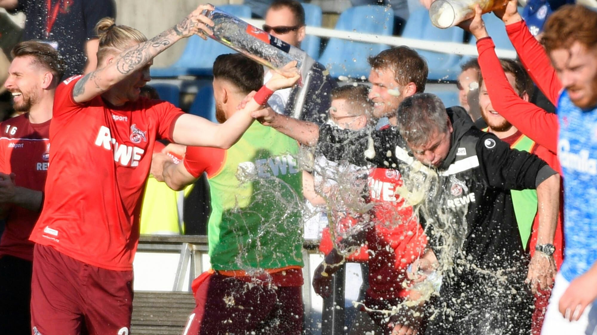 Die FC-Profis feiern Friedhelm Funkel nach dem Klassenerhalt in der Relegation in Kiel mit Bierduschen.