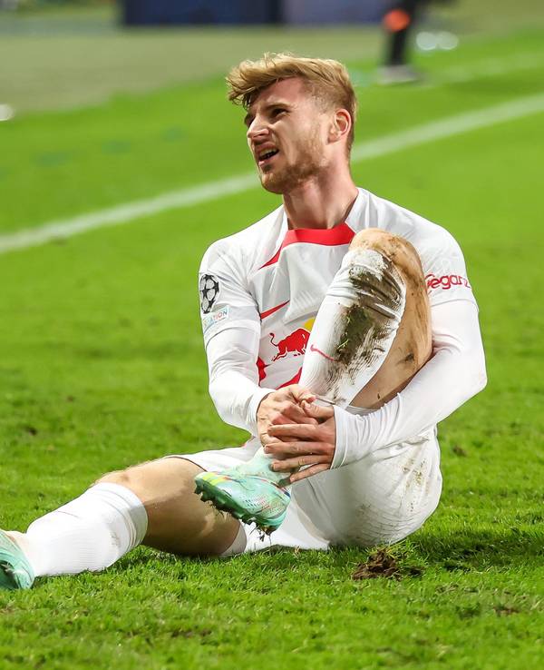 Timo Werner sitzt auf dem Rasen und hält sich das Bein.
