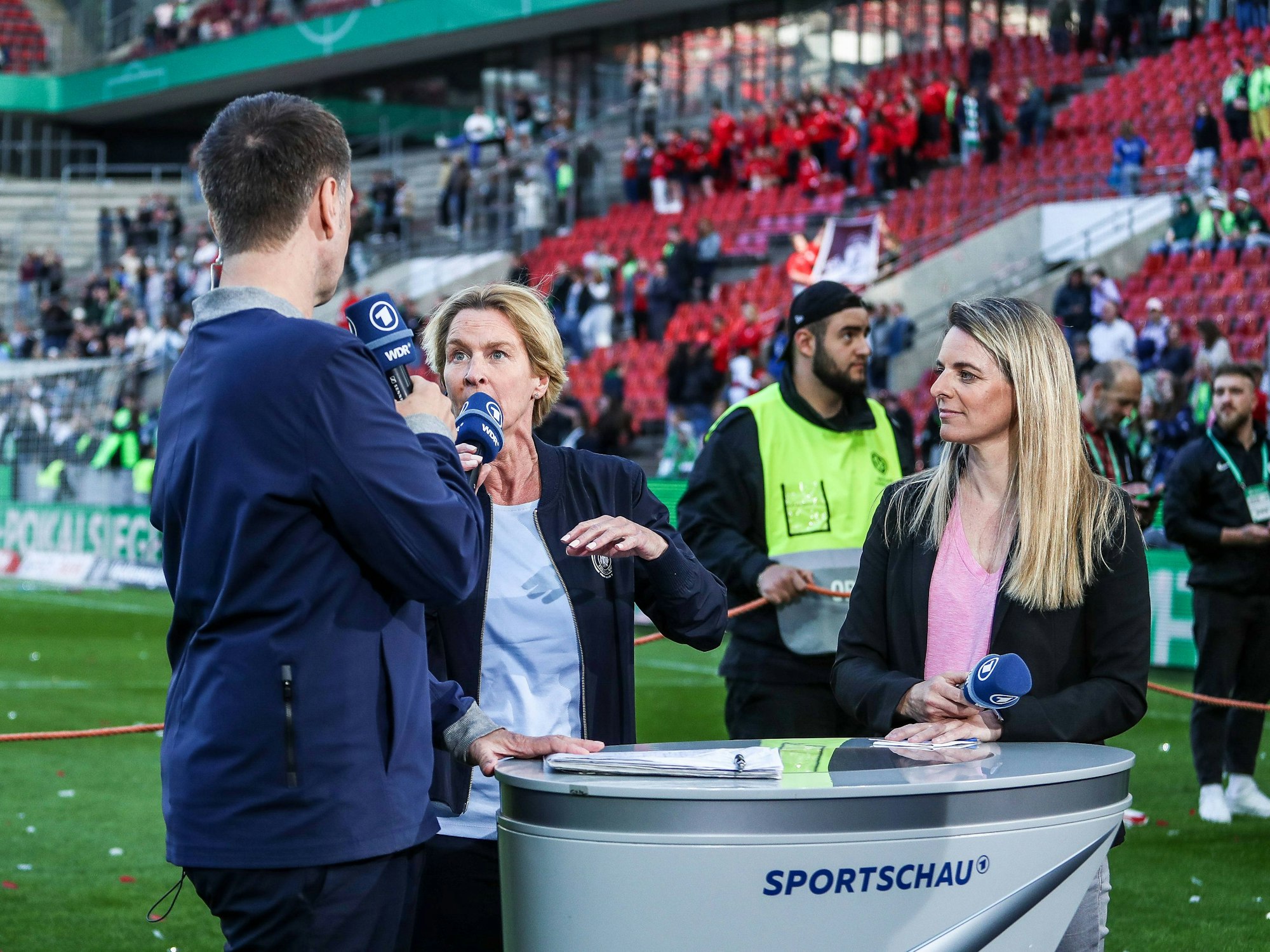 Nia Künzer am 18. Mai 2023 mit Ex-Bundestrainerin Martina Voss-Tecklenburg und Claus Lufen am ARD-Pult im Rhein-Energie-Stadion.