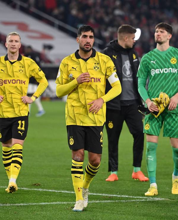 Marco Reus, Emre Can und Gregor Kobel laufen enttäuscht über den Rasen.