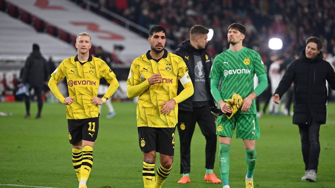 Marco Reus, Emre Can und Gregor Kobel laufen enttäuscht über den Rasen.