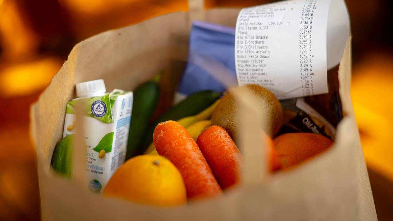 Ein Kassenbon liegt auf den Lebensmitteln in einer Einkaufstüte: Viele Supermärkte listen ihre Eigenmarken zu günstigeren Preisen als Discounter, das hat eine neue Erhebung ergeben.