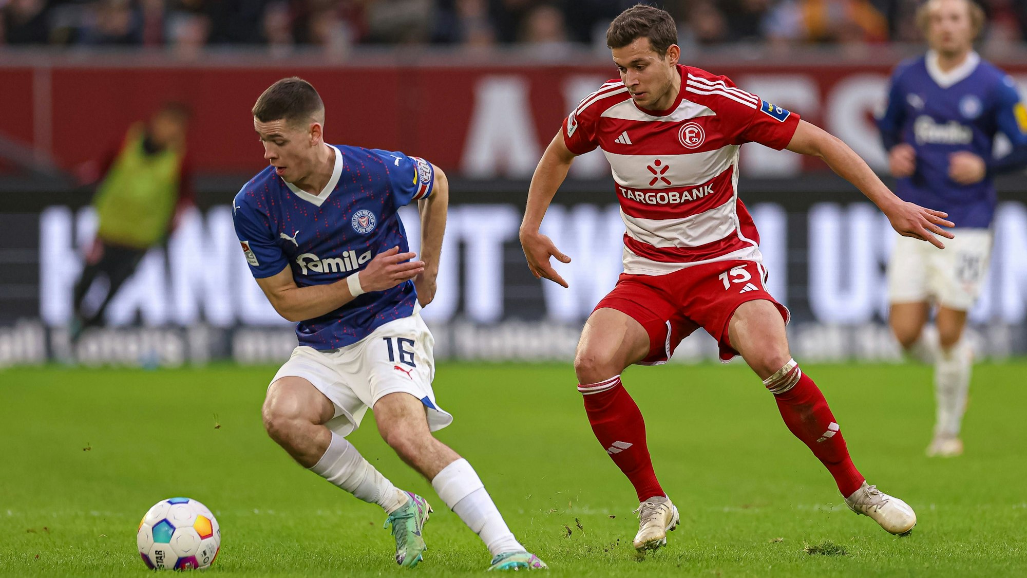 Philipp Sander von Holstein Kiel im Duell um den Ball mit Tim Oberdorf von Fortuna Düsseldorf.