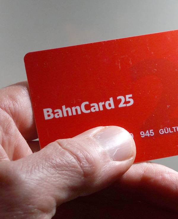 Ein Mann hält eine BahnCard 25 in der Hand.