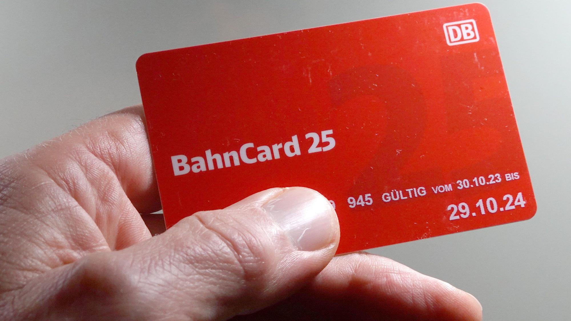 Ein Mann hält eine BahnCard 25 in der Hand.