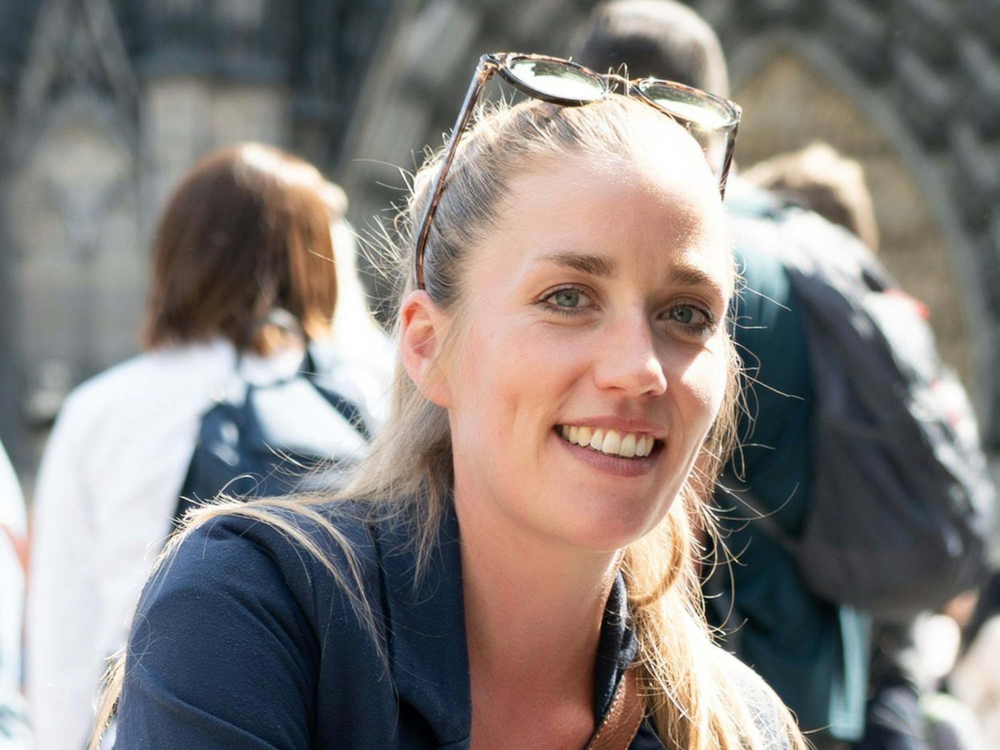 Ruth Wolfram sitzt vorm Kölner Dom und lächelt.