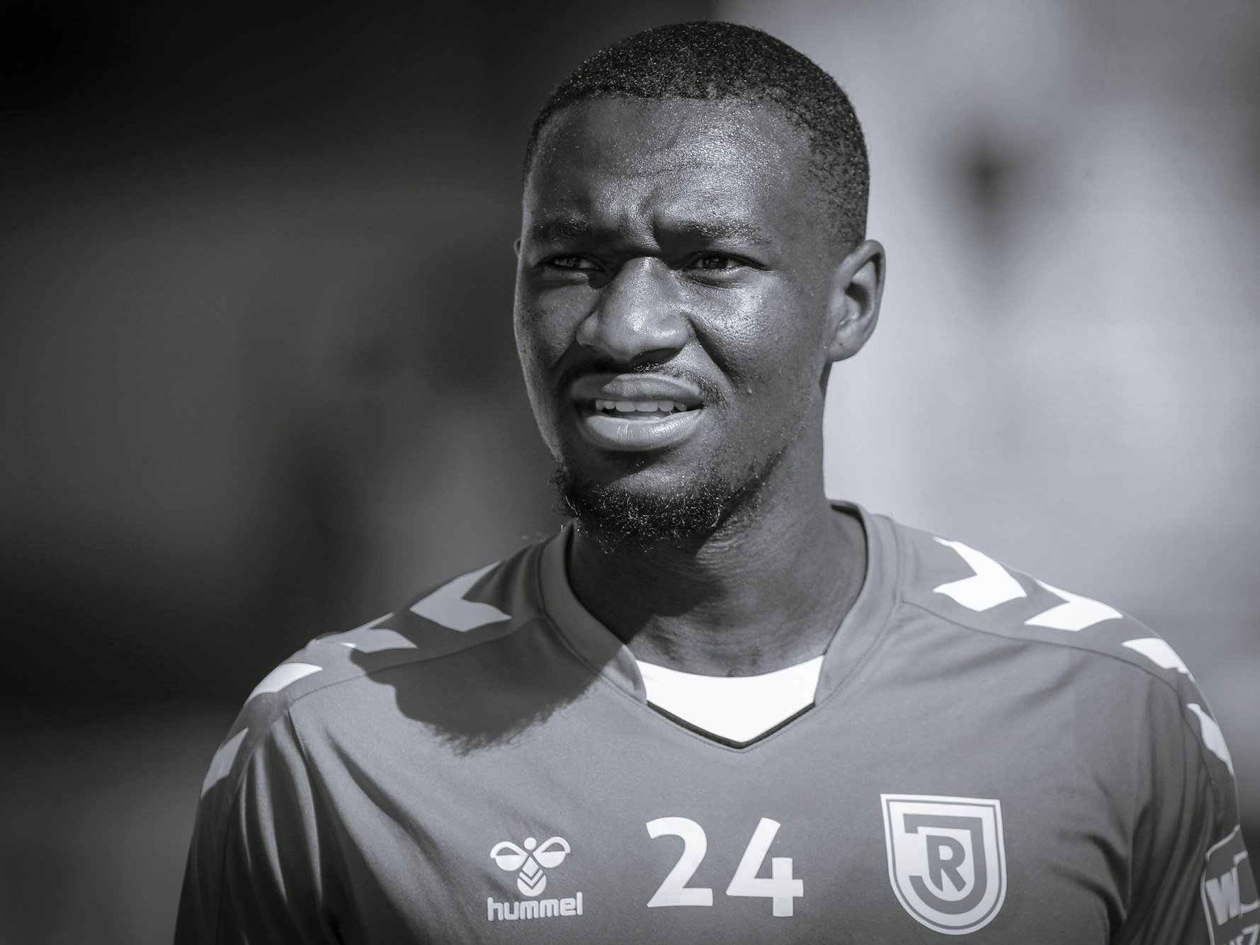 Der verstorbene Agyemang Diawusie lächlet.