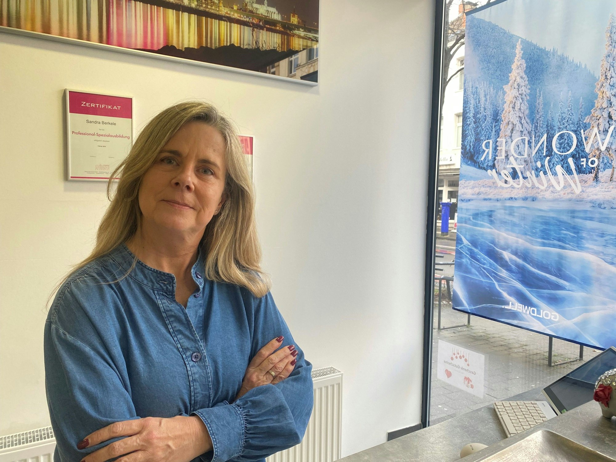 Eine Frau steht mit verschränkten Armen in einem Geschäft.