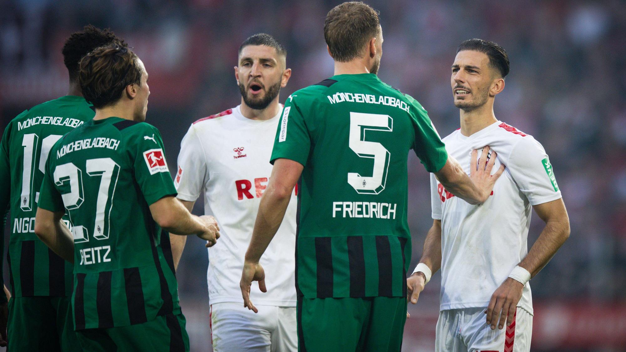 Die FC-Profis Leart Pacarada (r.) und Jeff Chabot diskutieren im Derby mit ihren Gladbacher Gegenspielern.
