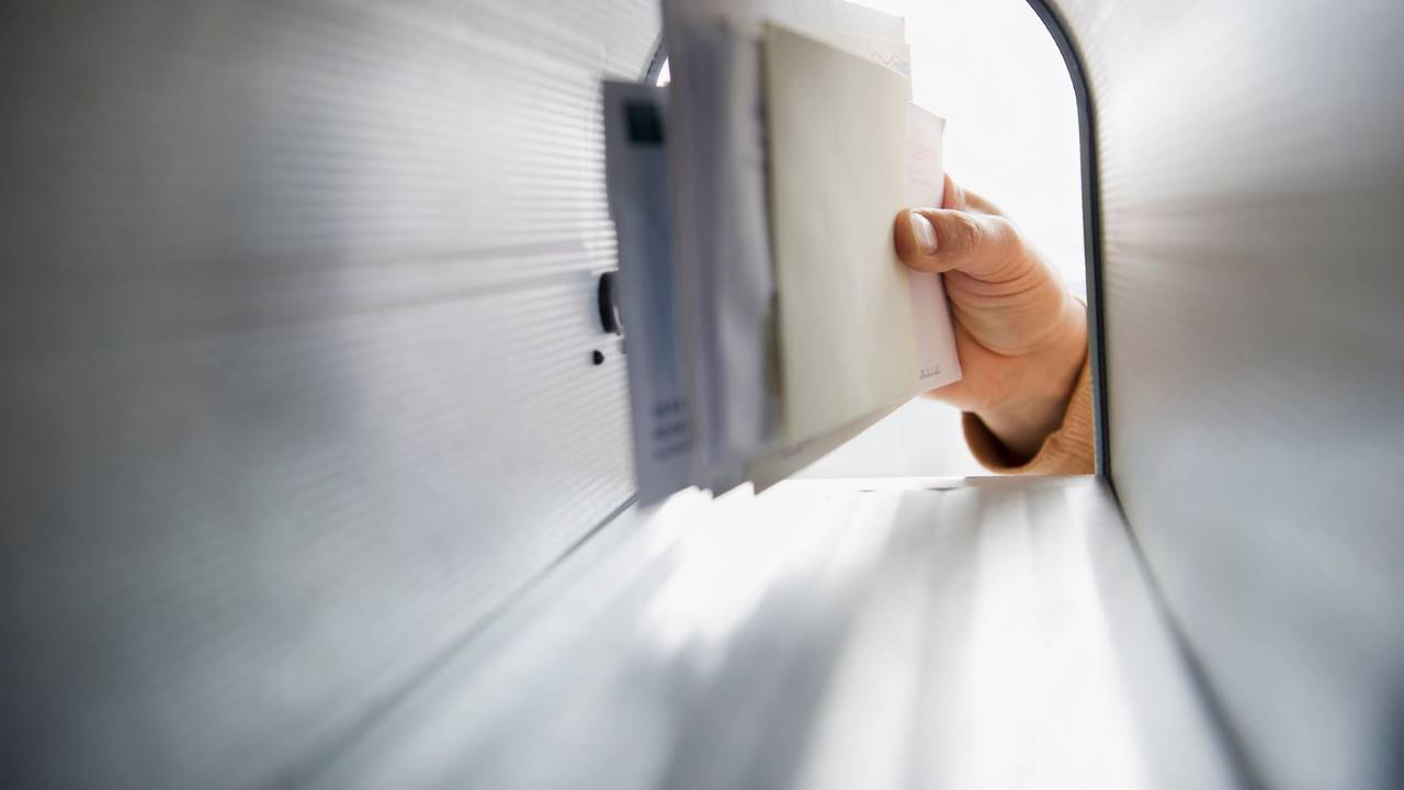 Briefe werden aus erinem Briefkasten geholt.