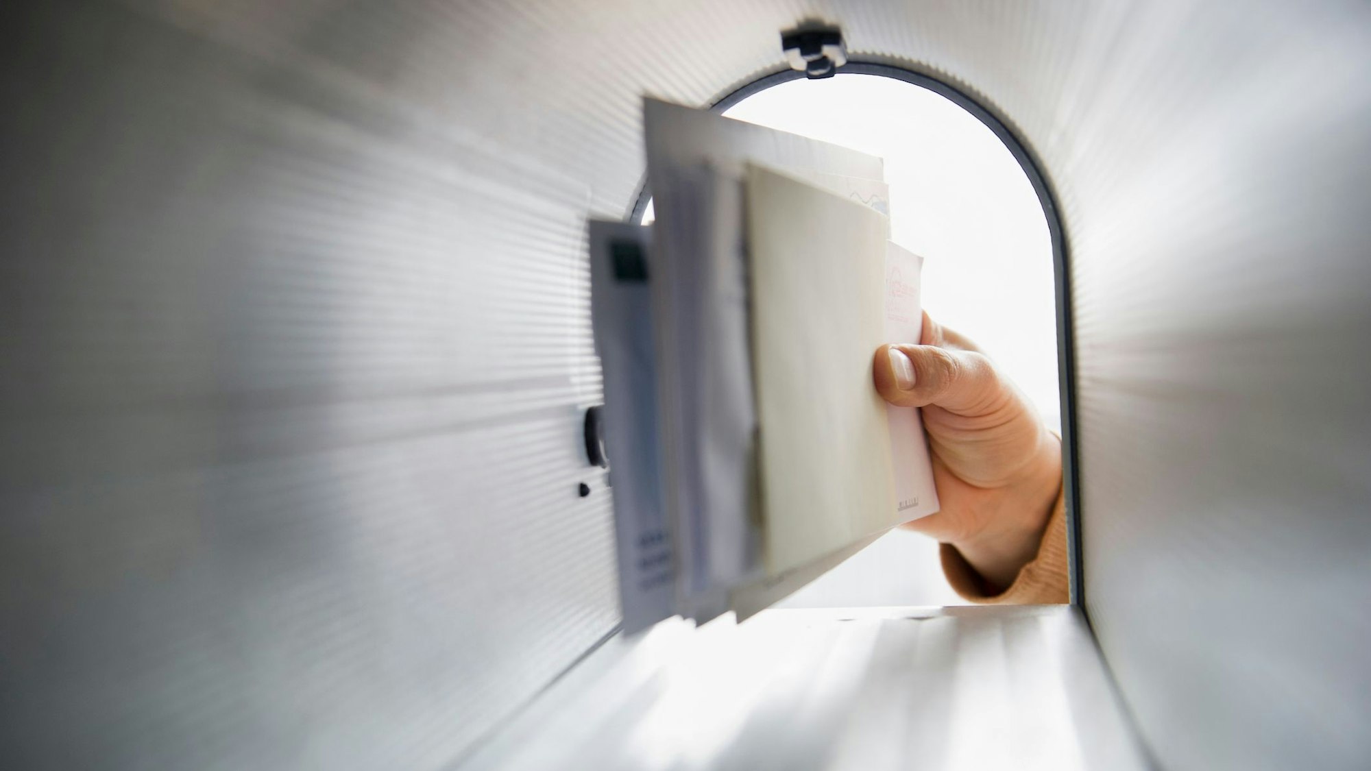 Briefe werden aus erinem Briefkasten geholt.