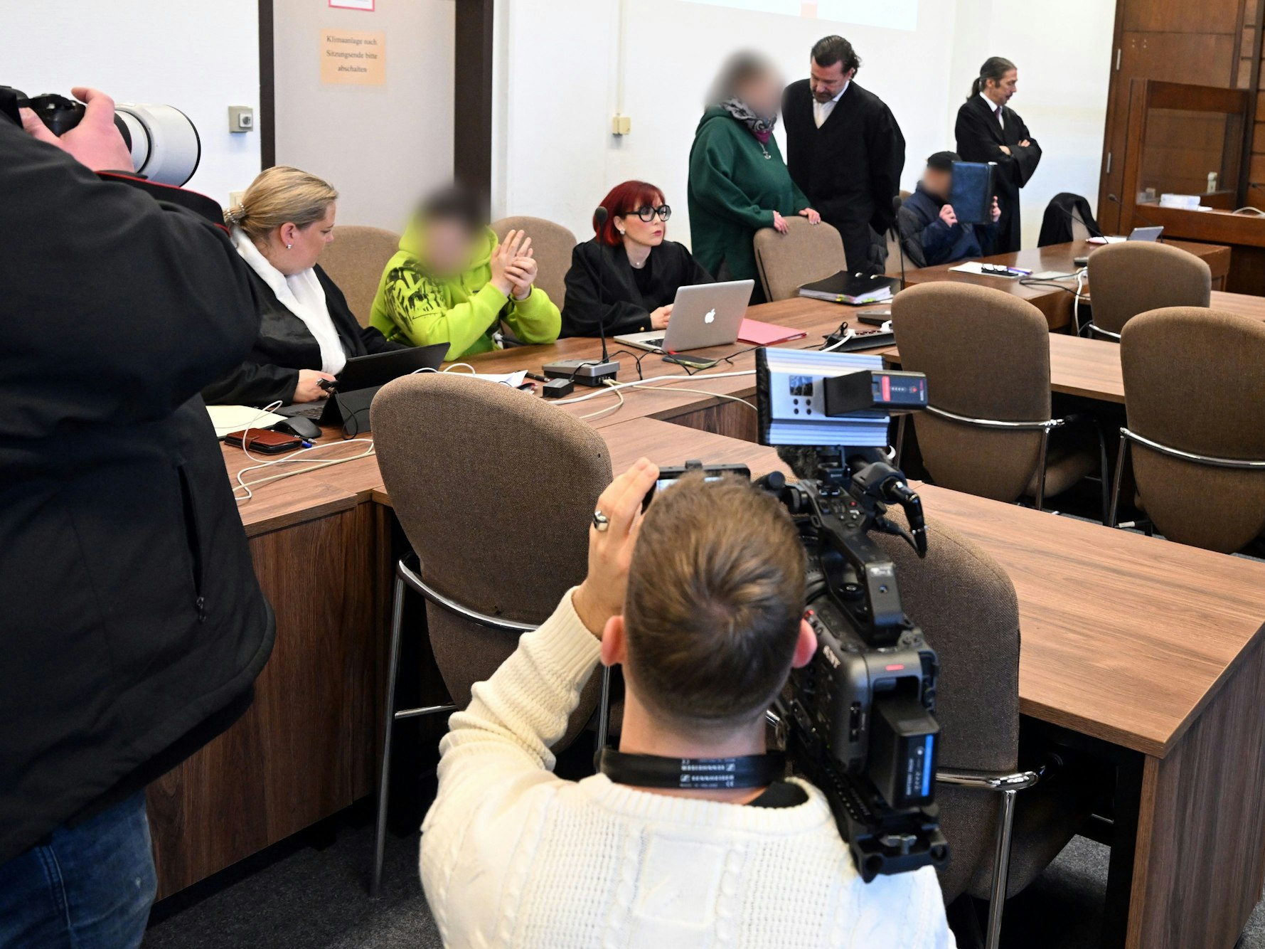 Die Angeklagten warten mit ihren Rechtsanwälten auf den Beginn des Prozesses.