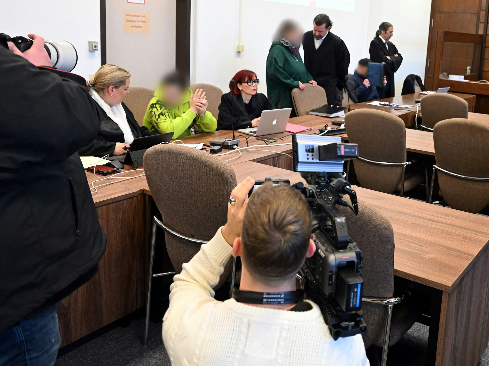 Die Angeklagten warten mit ihren Rechtsanwälten auf den Beginn des Prozesses.
