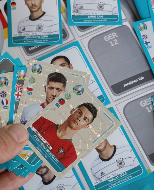 Ein Mann hält mehrere Sammel-Sticker von Panini für die EM 2021 in der Hand. Bei der EM 2024 übernimmt Konkurrent Topps die Rechte.