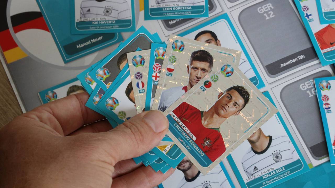 Ein Mann hält mehrere Sammel-Sticker von Panini für die EM 2021 in der Hand. Bei der EM 2024 übernimmt Konkurrent Topps die Rechte.