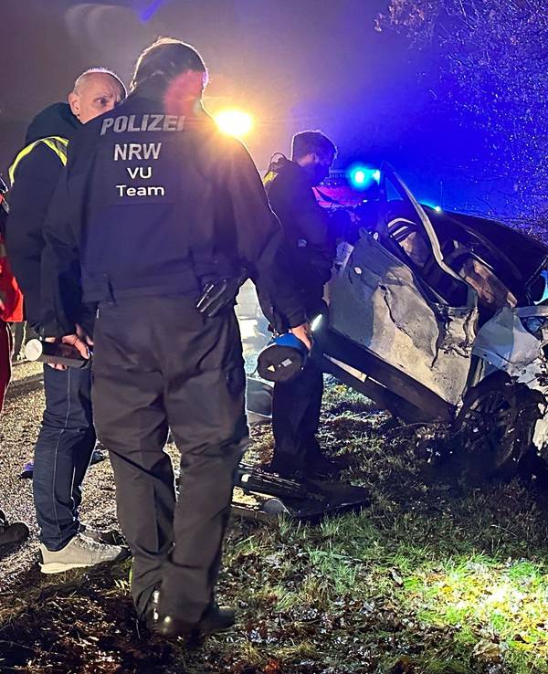 Polizisten stehen am Ort eines Autounfalls nahe Reichshof.