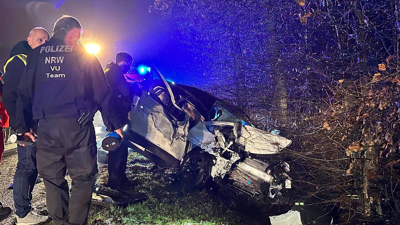 Polizisten stehen am Ort eines Autounfalls nahe Reichshof.