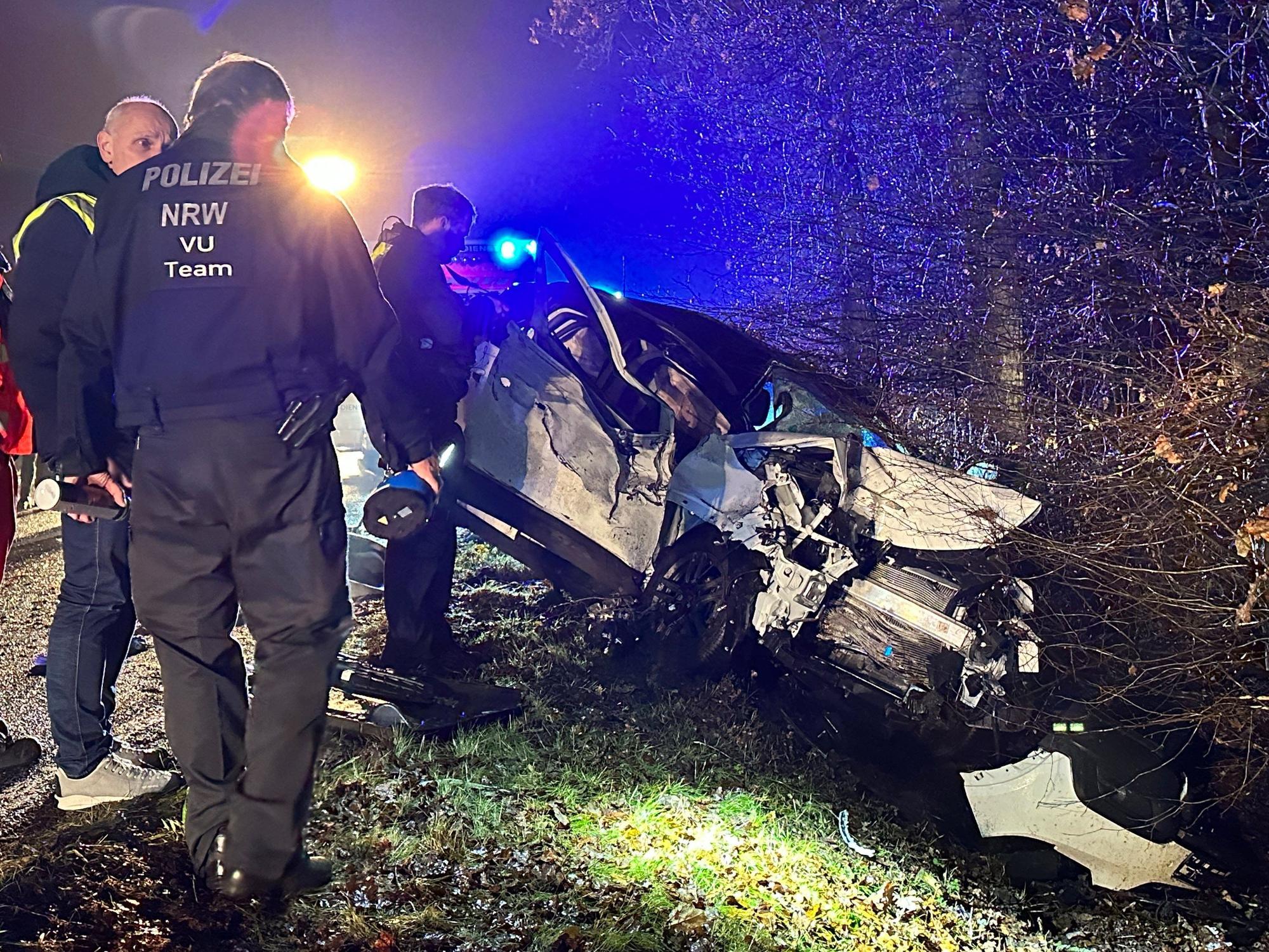 Polizisten stehen am Ort eines Autounfalls nahe Reichshof.