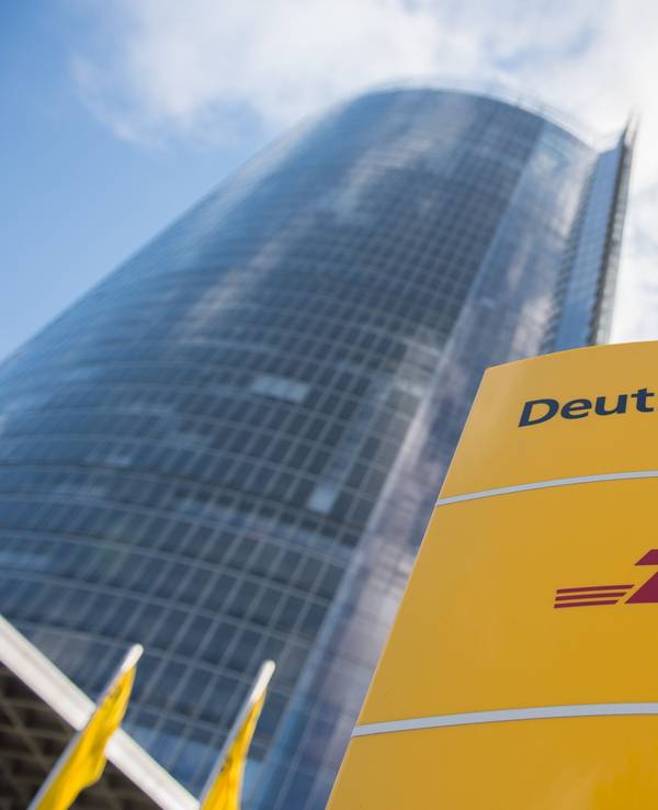 Ein Schild mit dem Logo der Deutschen Post und von DHL steht an der Zentrale des Logistikonzerns.