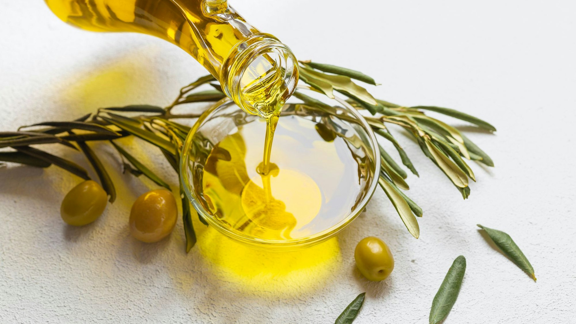 Olivenöl wird in eine Schale gegossen