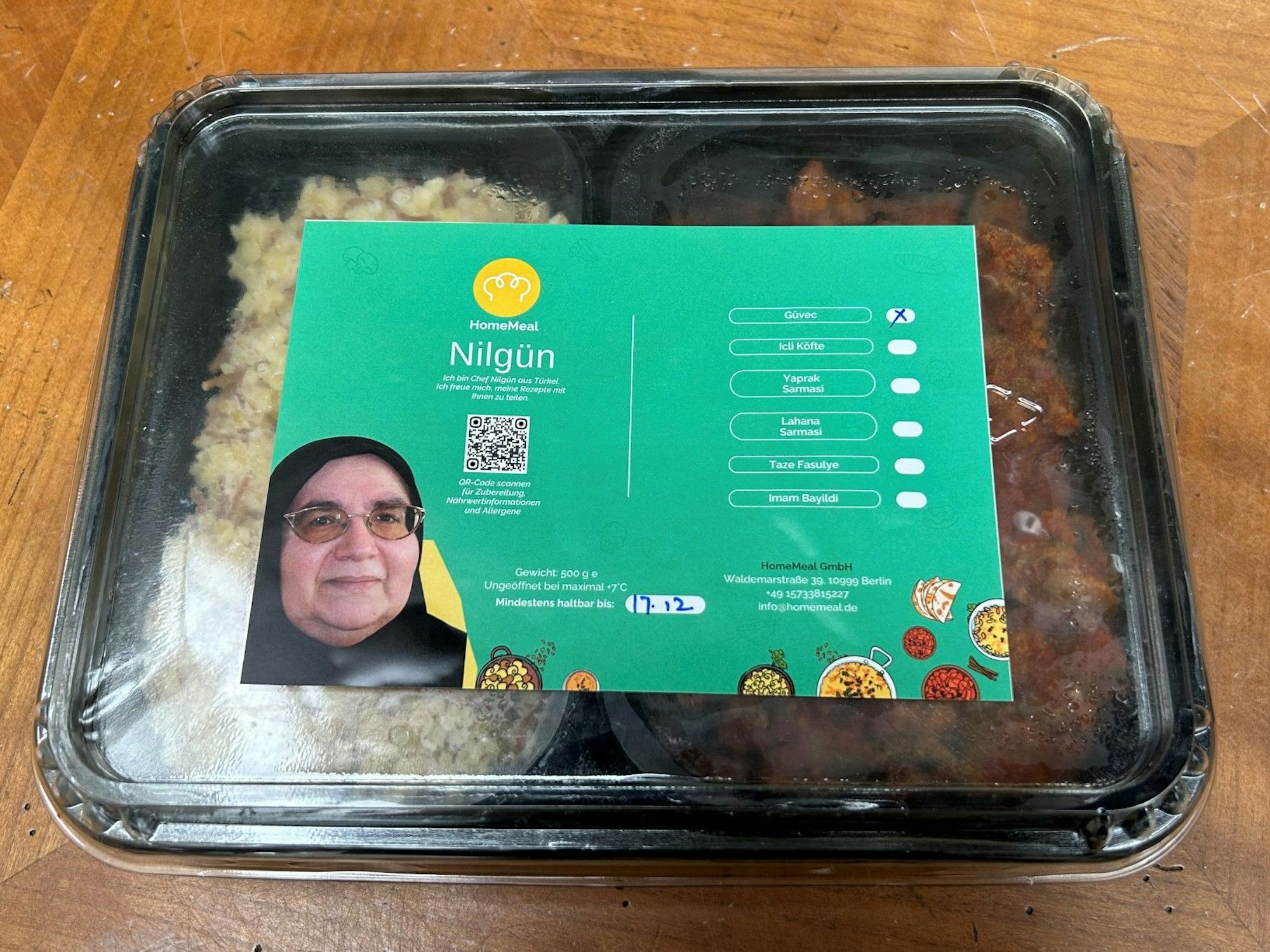 Eine Portion Essen in einer Plastikschale steht auf einem Tisch.