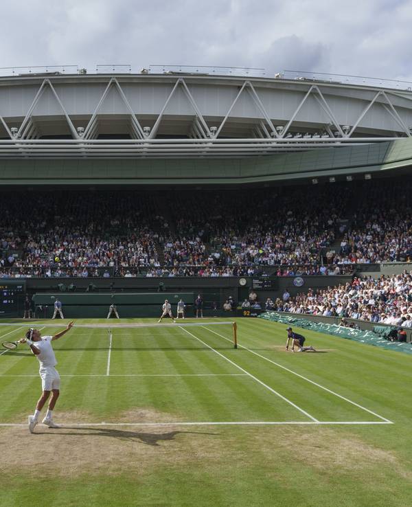 Roger Federer (vorne) schlägt auf dem Centre Court auf.